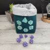 Panière à dés carré verte et grise brodée avec un set de dés de jeu de rôle (d20, d12, d10, d8, d6, d4)