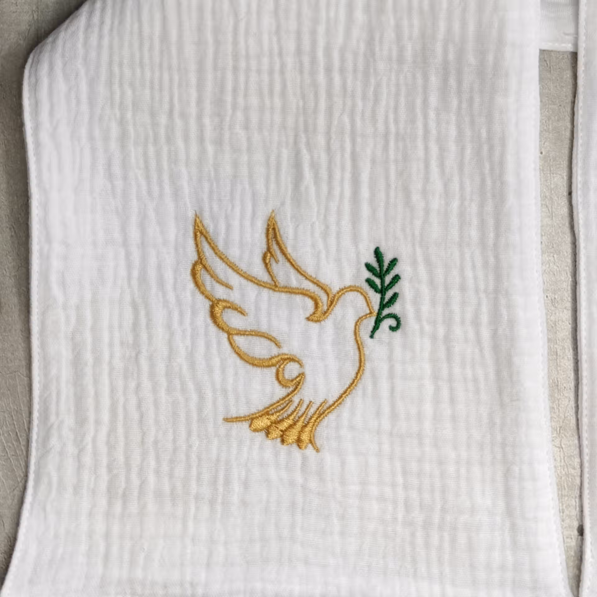 broderie d'une colombe dorée et d'un rameau vert