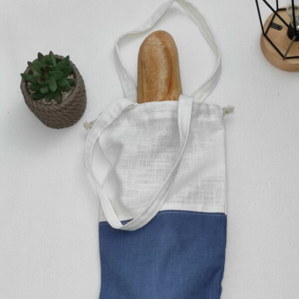 sac à pain bicolore bleu contenant une baguette