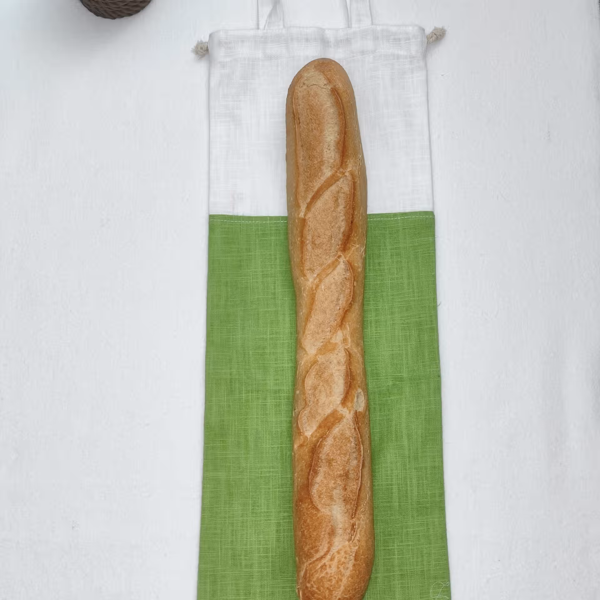 sac à pain bicolore vert et blanc avec une baguette