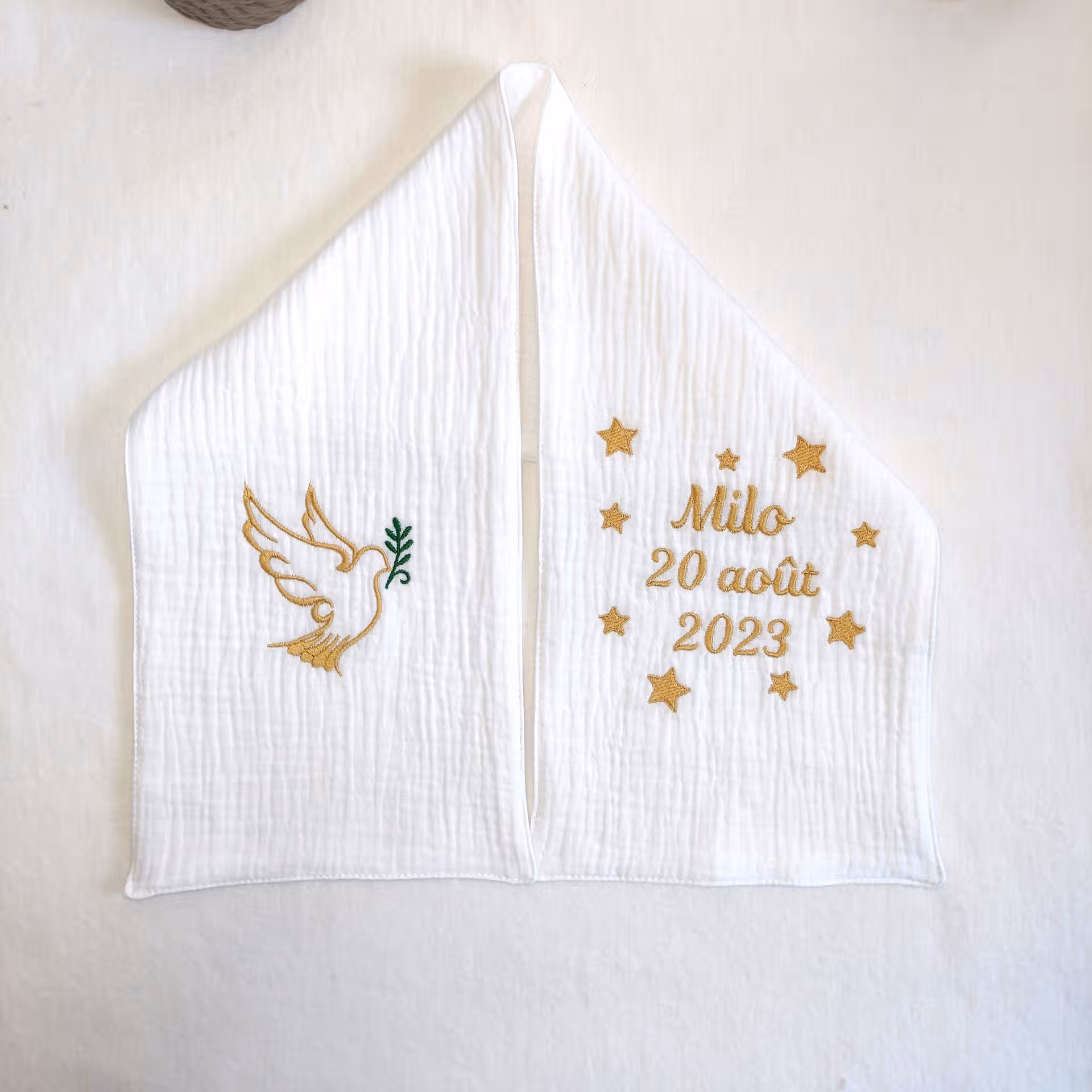 Echarpe de baptême en double gaz blanche brodée d'une colombe dorée et d'un rameau vert ainsi que d'une personnalisation