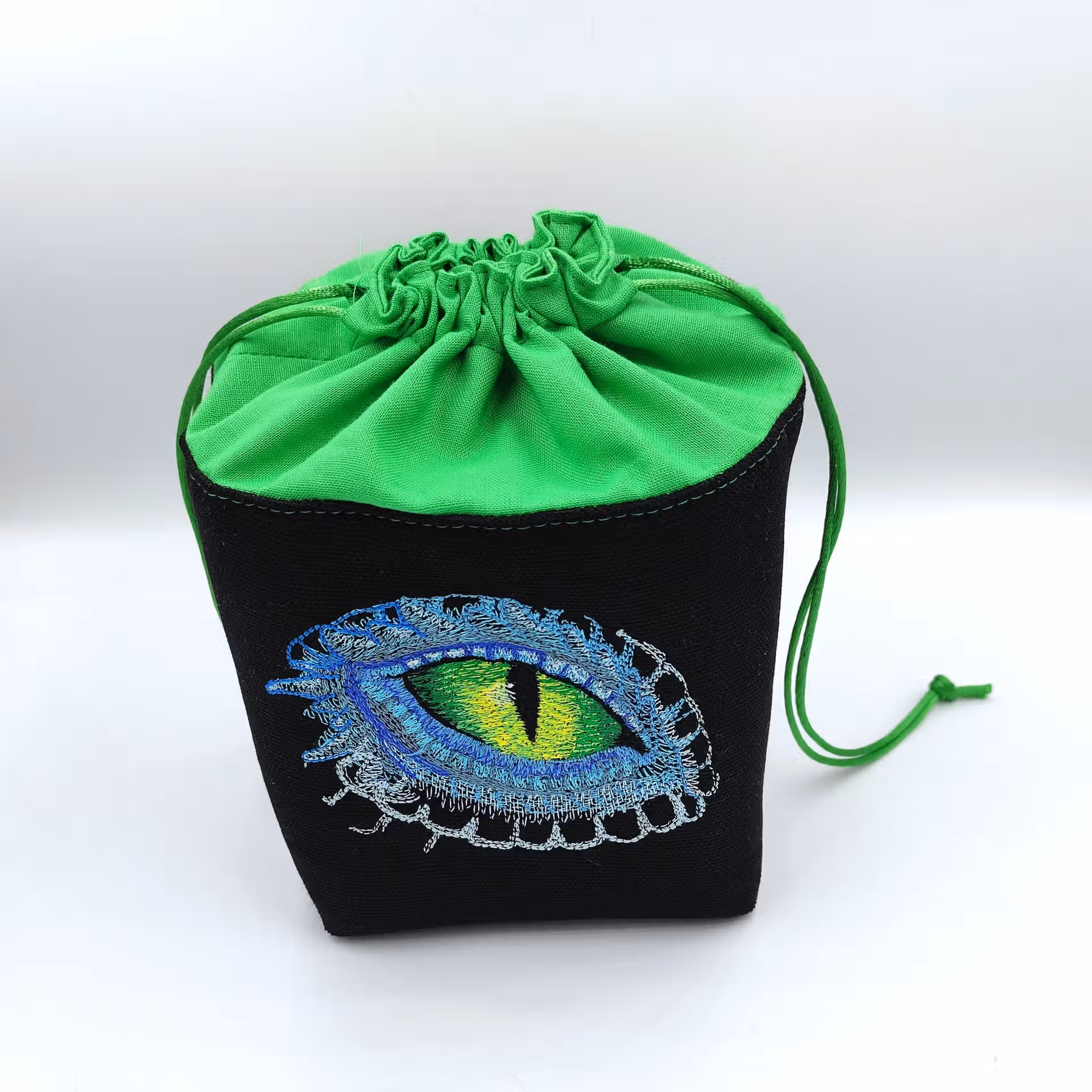 Bourse à dés carrée noire et verte - motif œil de dragon fermée Bourse à dés carrée noire et verte - motif œil de dragon fermée