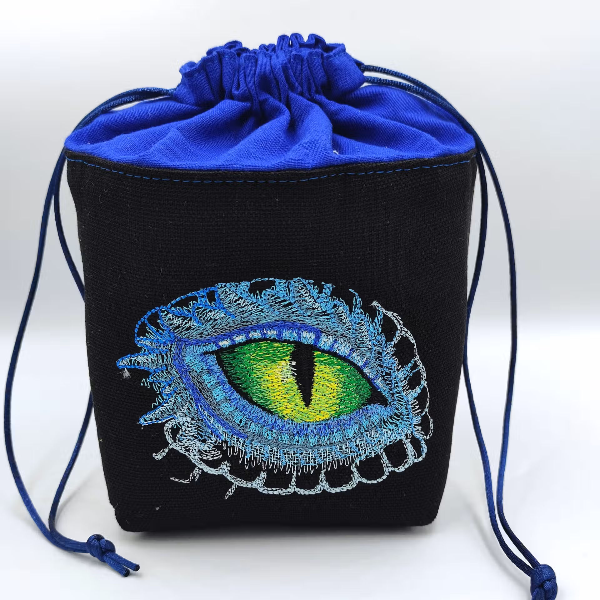Bourse à dés carrée noire et bleue - motif œil de dragon fermée Bourse à dés carrée noire et bleue - motif œil de dragon fermée
