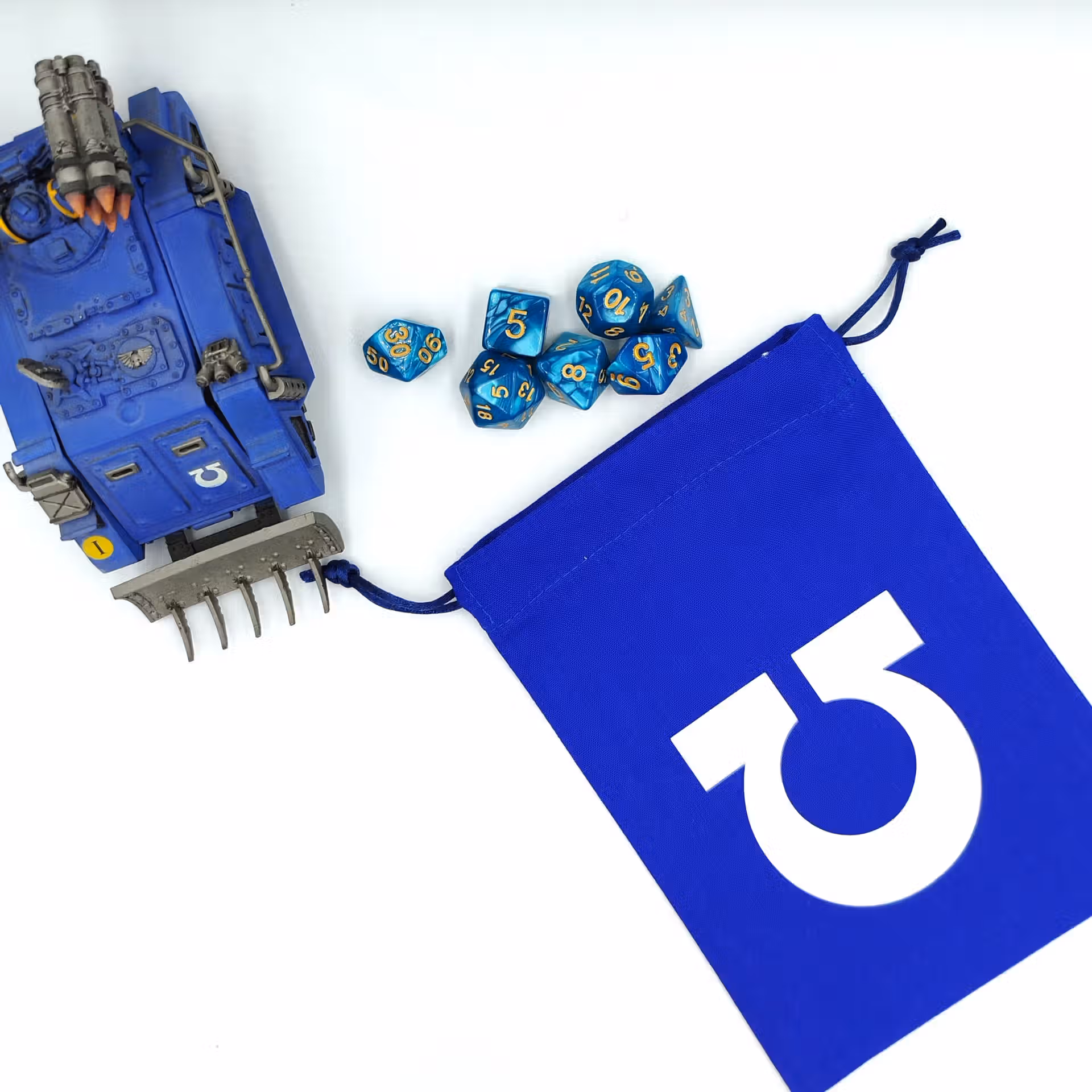 bourse à dés bleu avec le symbole oméga renversée devant un whirlwind ultramarine mk1 et des dés
