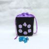 bourse à dés carré noire brodée jeu de rôle violet fermée avec des dés