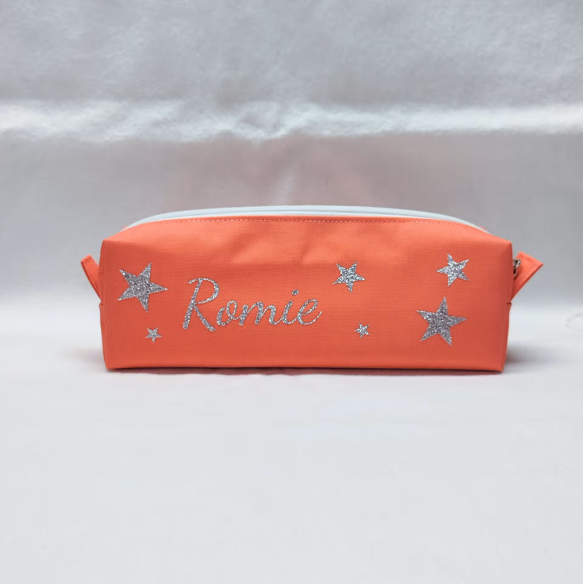 Trousse rose personnalisée avec un prénom et des étoiles brillante argentée Trousse rose personnalisée avec le prénom Romie et des étoiles brillante argentée