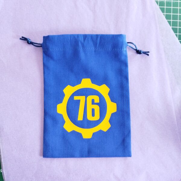 Bourse à dés plate bleue inspirée de l'univers Fallout avec porte crantée et numéro d'abri 76 Vault Tec