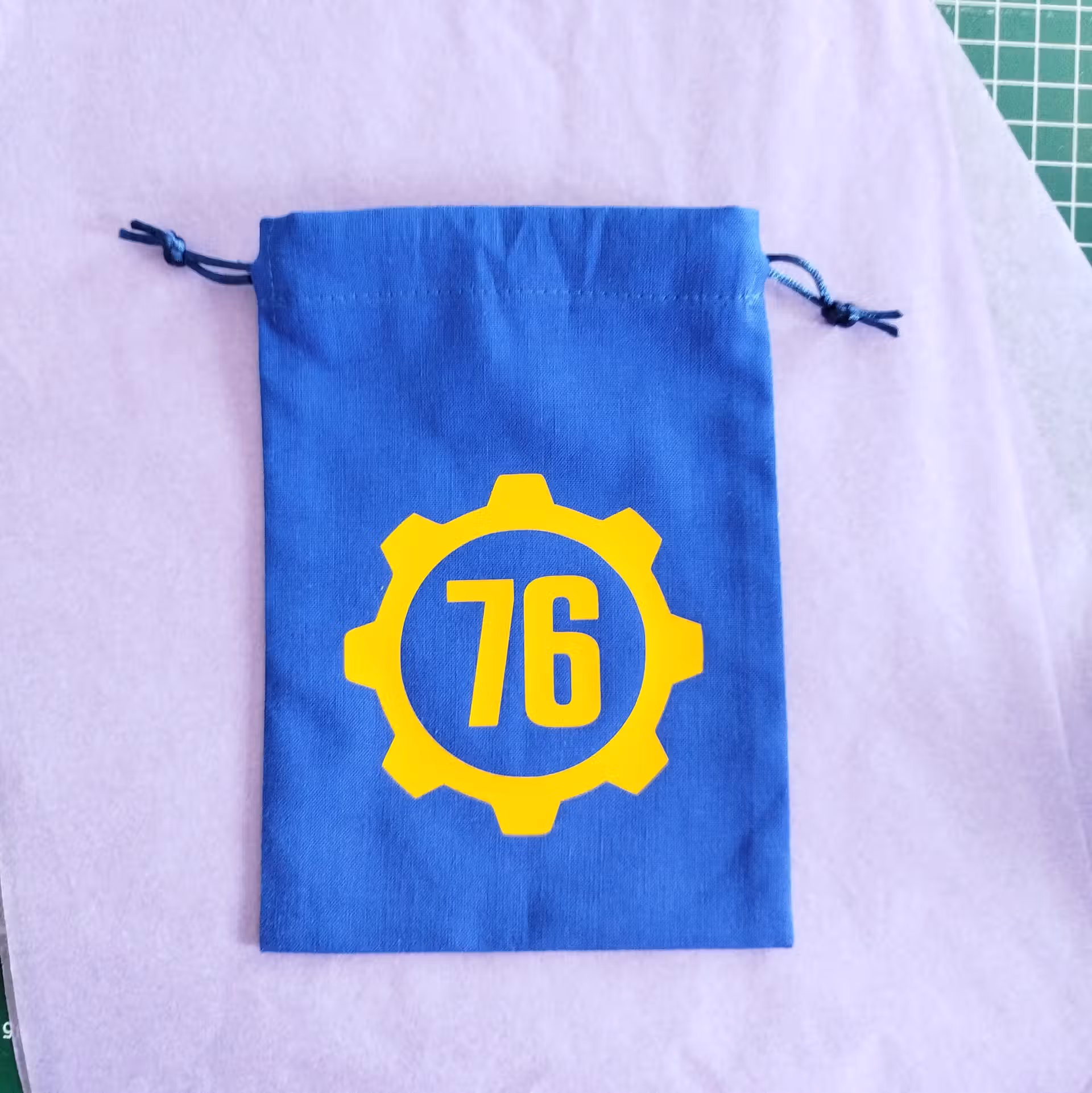 Bourse à dés plate bleue inspirée de l'univers Fallout avec porte crantée et numéro d'abri 76 Vault Tec